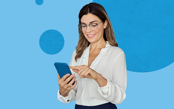 Donna sorridente in piedi che usa uno smartphone.